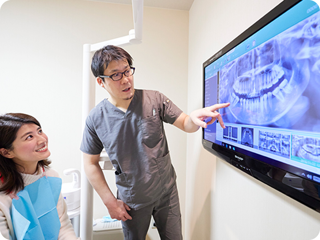 大森歯科が患者さんに治療の説明をしている