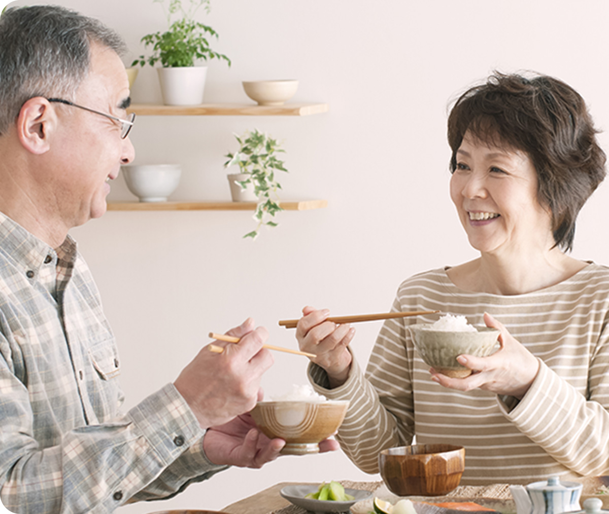 夫婦がお互いの顔を見ながら食事をしている