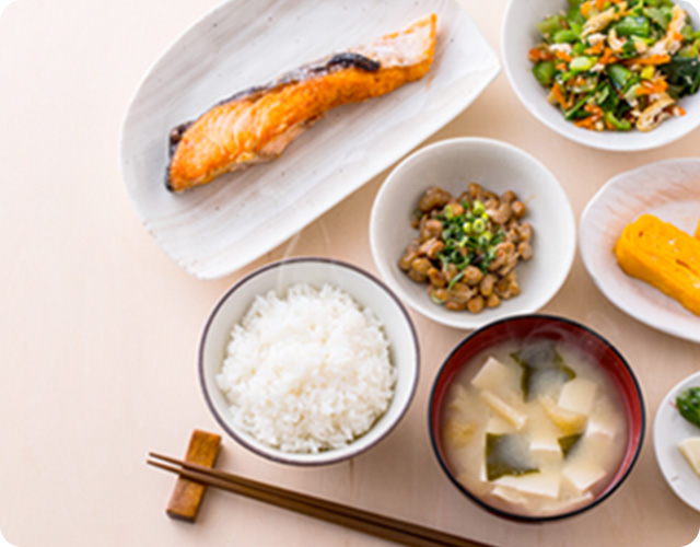 食卓に器に盛ったご飯や味噌汁や魚が並んでいる